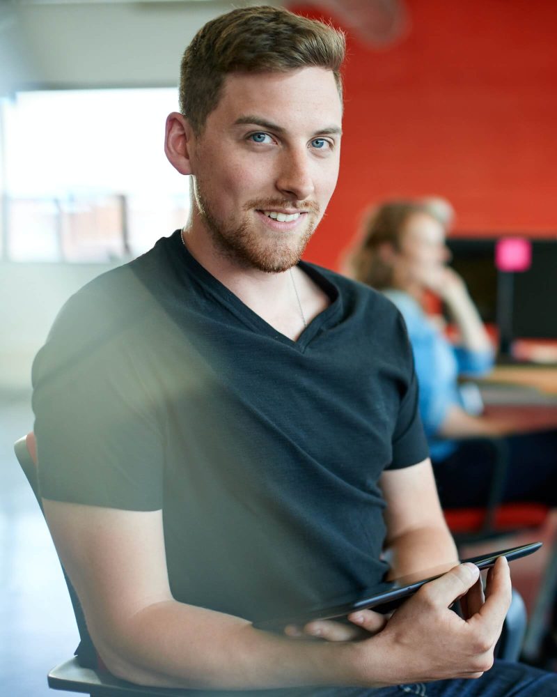 confident-male-designer-working-on-a-digital-tablet-in-red-creative-office-space-3.jpg